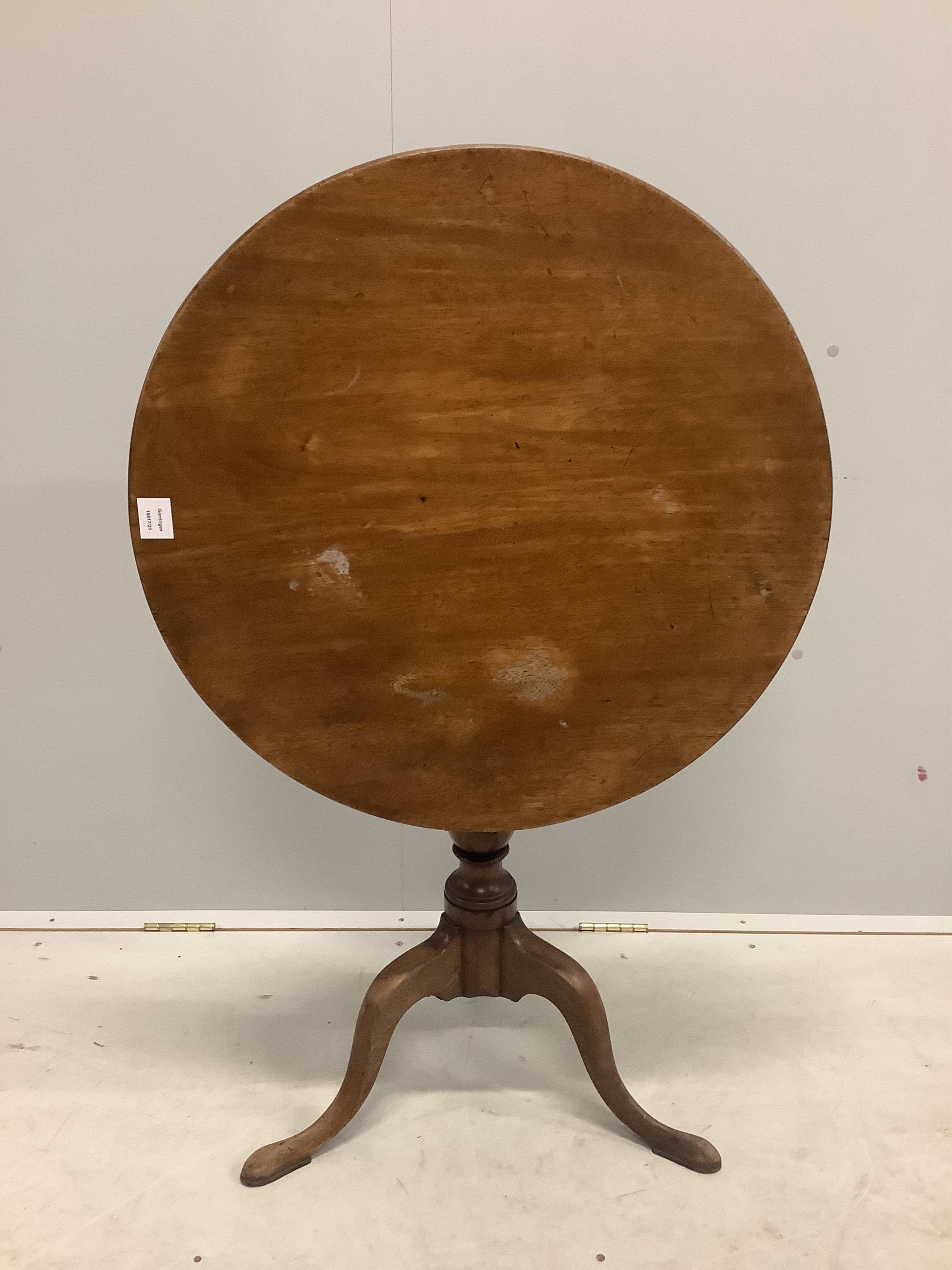 A George III circular mahogany tilt top tripod tea table, diameter 69cm, height 72cm. Condition - fair